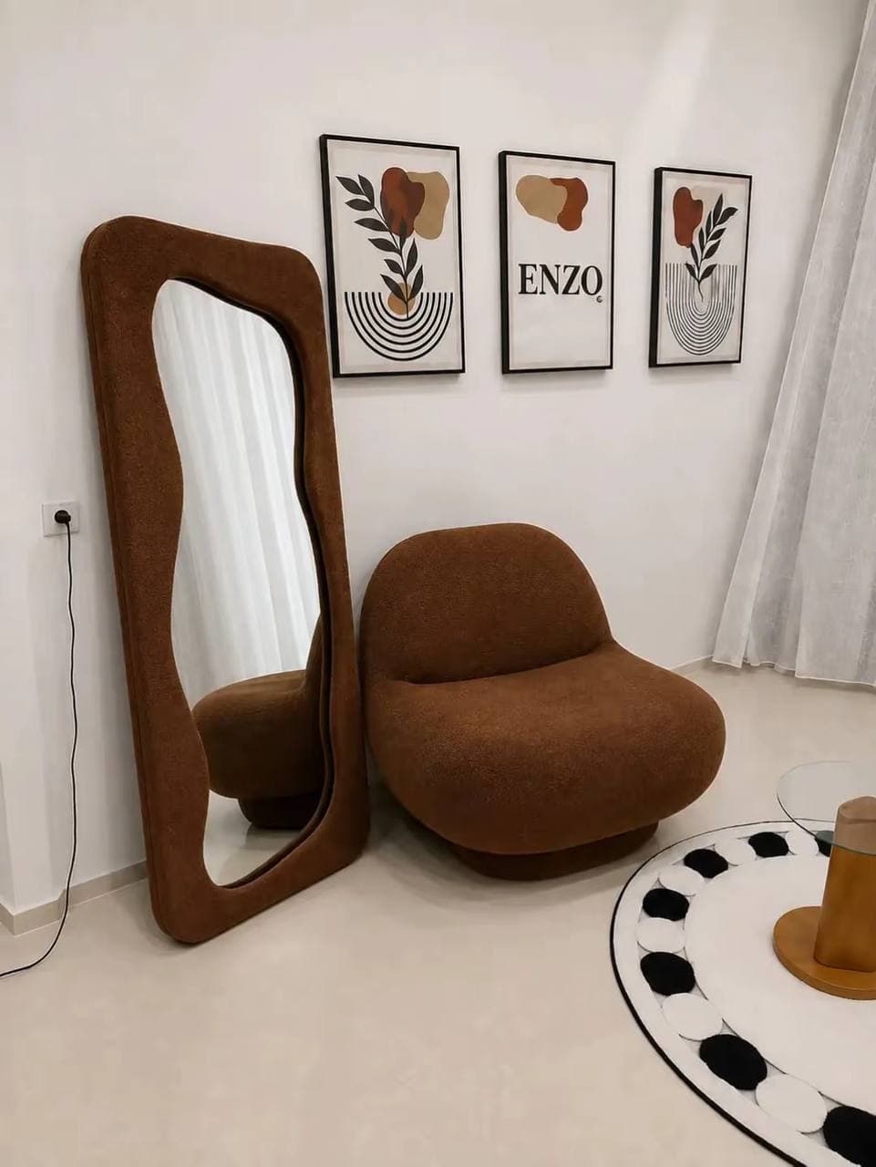 Rust boucle wavy floor mirror beside a matching accent chair