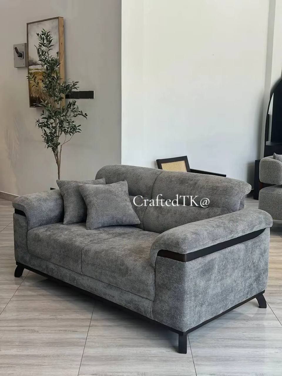 Grey textured three-seater sofa with dark wood trim